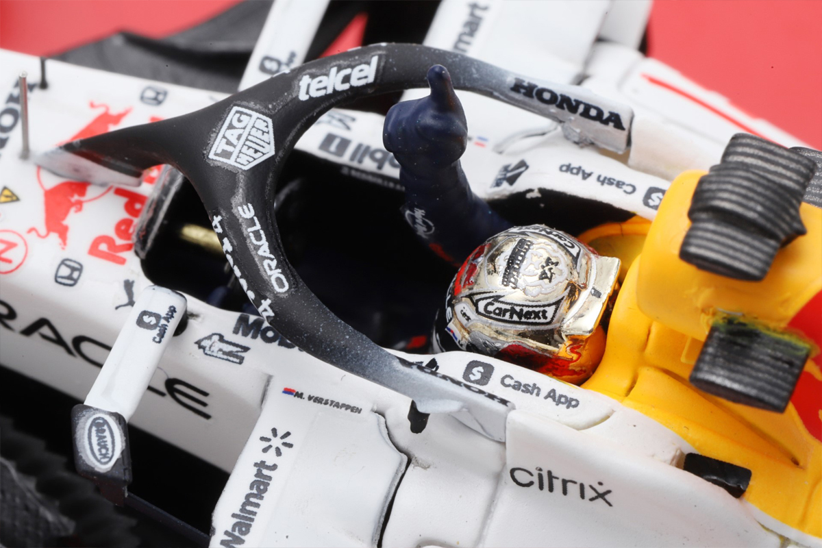 2022のチャンピオン記念のゴールドヘルメットを着用し、人差し指をかかげるデモラン中のフェルスタッペン選手のフィギュアを再現